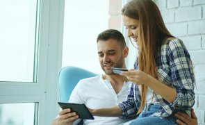 casal em casa escolhendo forma de pagamento com cartao e tablet casal em casa escolhendo forma de pagamento com cartao e tablet